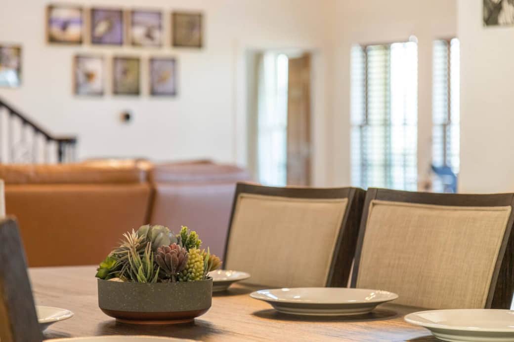 Dining room table, couch, and photos of property.