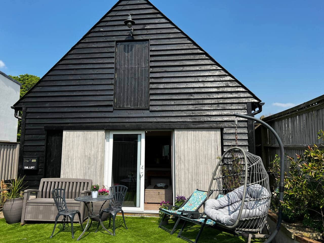 The Sail Loft is a converted garage with outside space to store a car and to enjoy the warmer weather. This is a view from the gated entrance and shows the patio doors which lead into the lounge area. 
