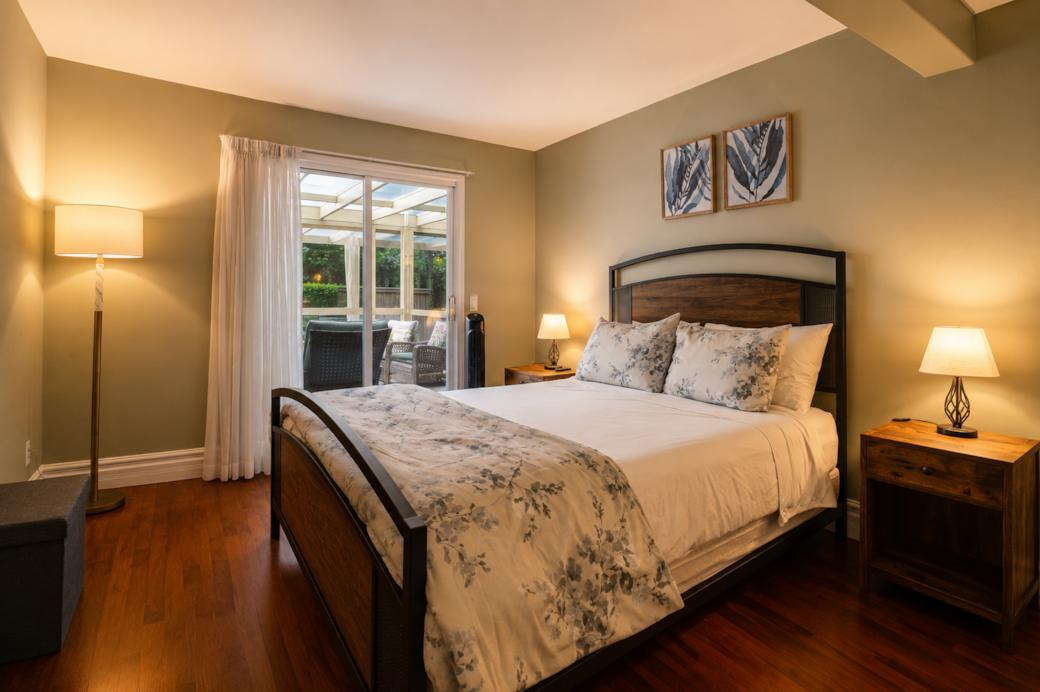 Quiet primary bedroom with direct access to the backyard and pool area.