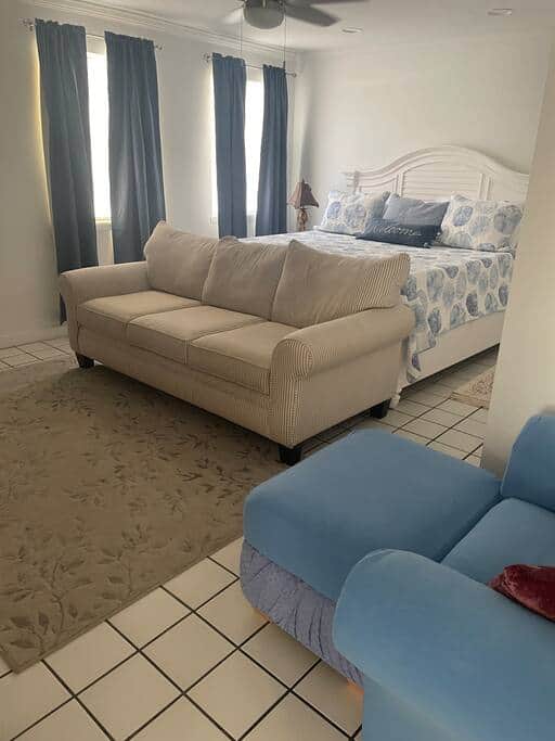 Master bedroom with a couch seating area in front of a large screen TV, And large walk-in closet