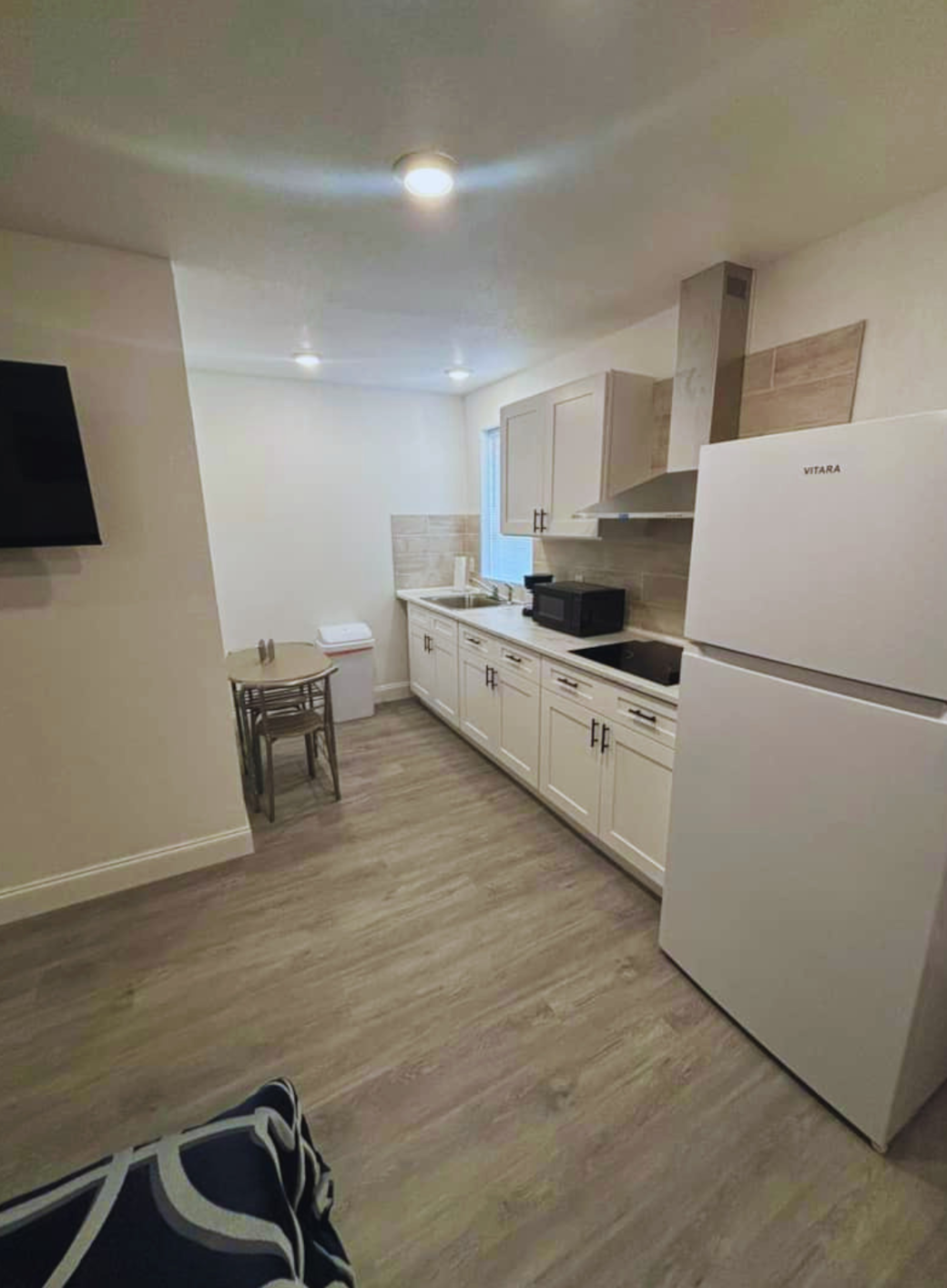 Bright kitchen and dining area for 2 with fridge, range hood, and essential amenities. Lakeland, FL
