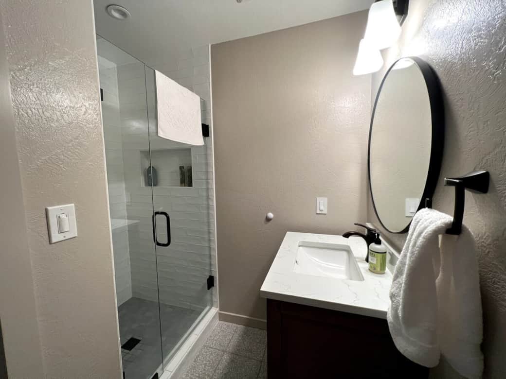 Bathroom 1 on the home's first floor features a full shower. All bathrooms have heated floors to keep your toes comfy in colder months. The bathroom is located right outside Bedroom 1.