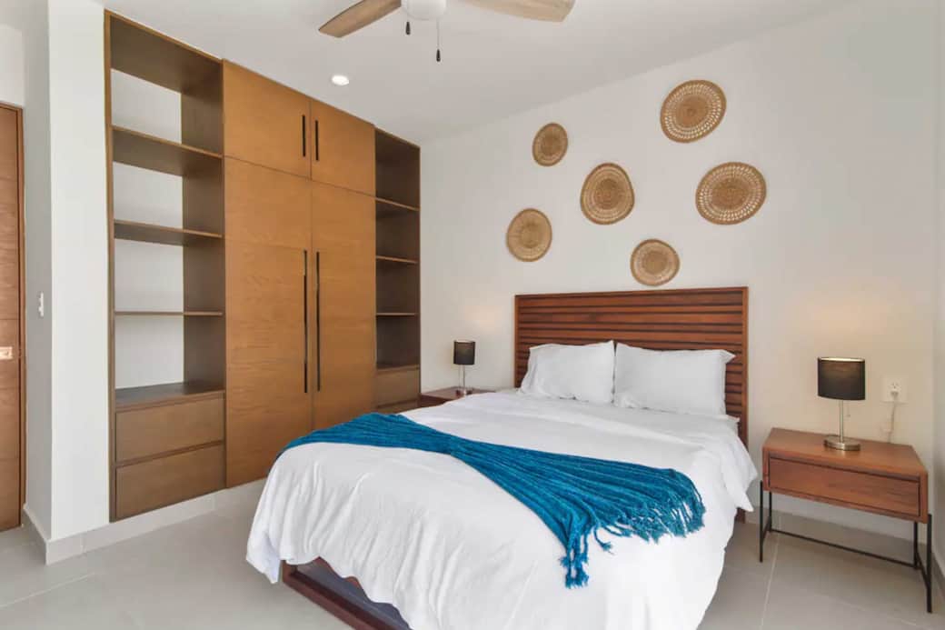 Spacious bedroom with full wardrobe, AC, and ceiling fan for comfort.