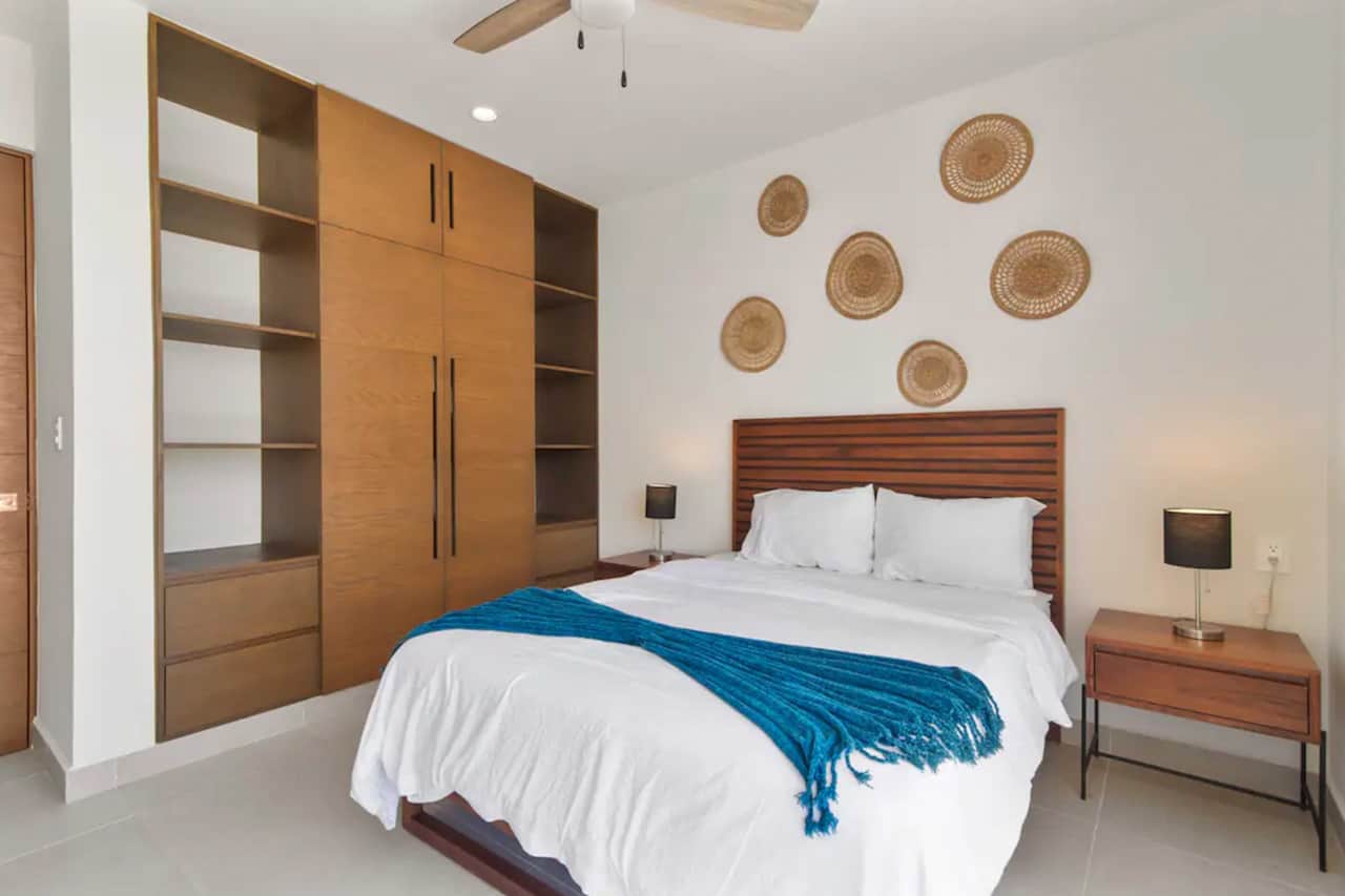 Spacious bedroom with full wardrobe, AC, and ceiling fan for comfort.