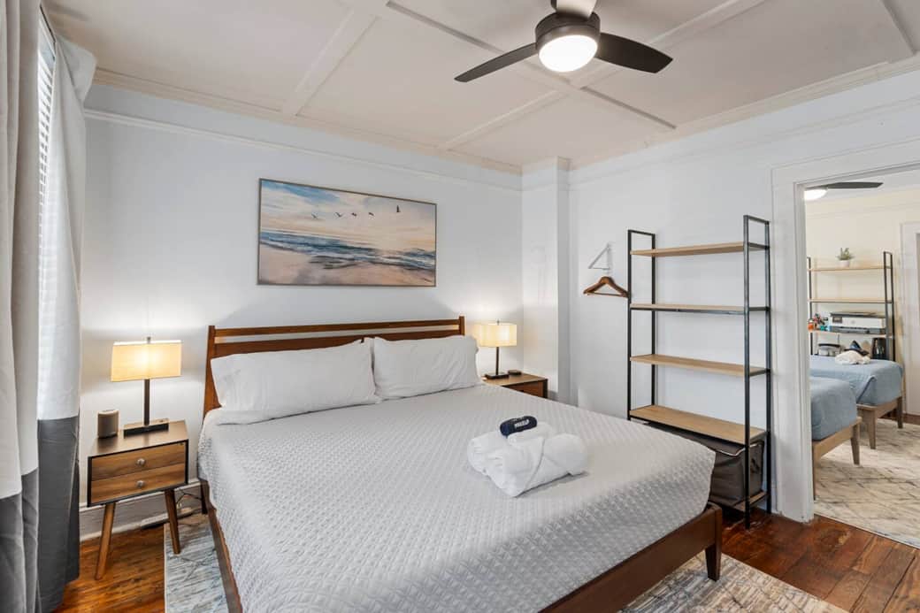 Bedroom #1 with the adjoining to bedroom #2 door open.  Large shelf and clothes hanger on the wall (2nd  clothes hanger behind door) to place all your belongings during your stay.  Extra blankets are provided on the bottom shelf.