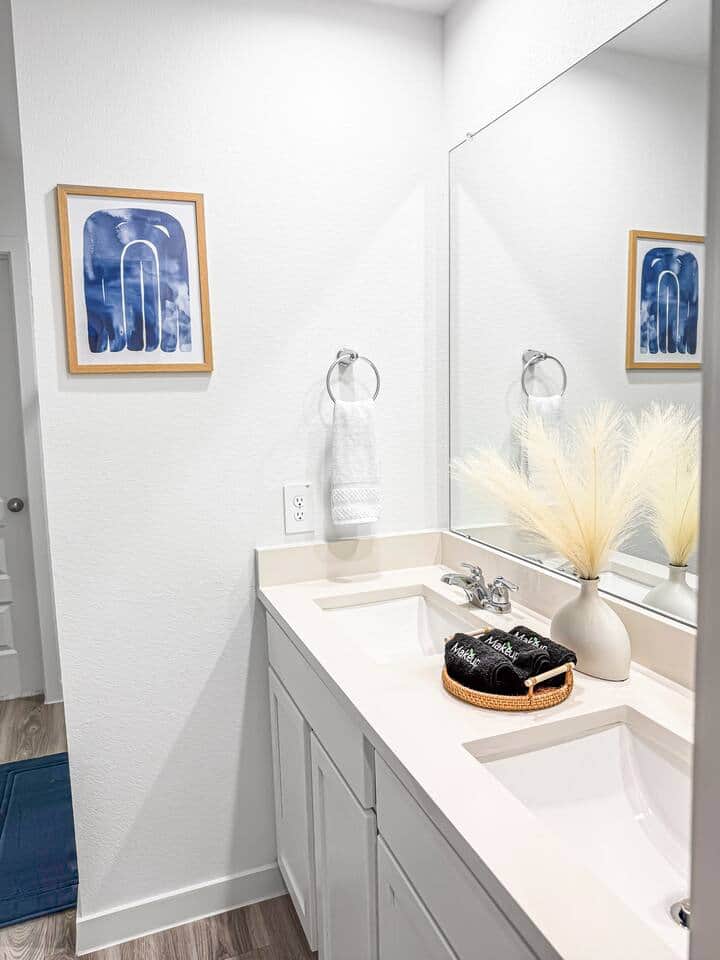 Bright, modern vanity with a double sink, ample counter space, and fresh linens. A clean, calming bathroom designed for easy mornings and comfortable stays.