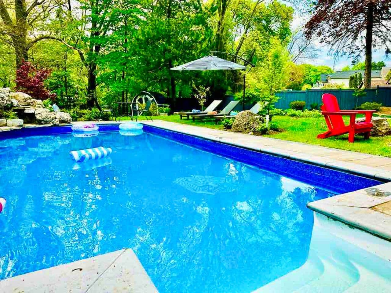 Our backyard offers a true resort like feel with a pool and connected tub, water fall, lounge chairs and a view of the beautiful ravine. 