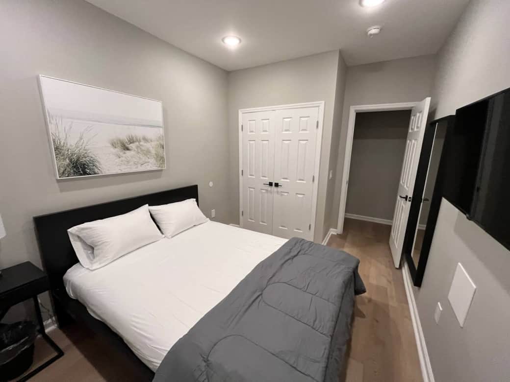Bedroom 1 with queen bed flat screen tv and closet.