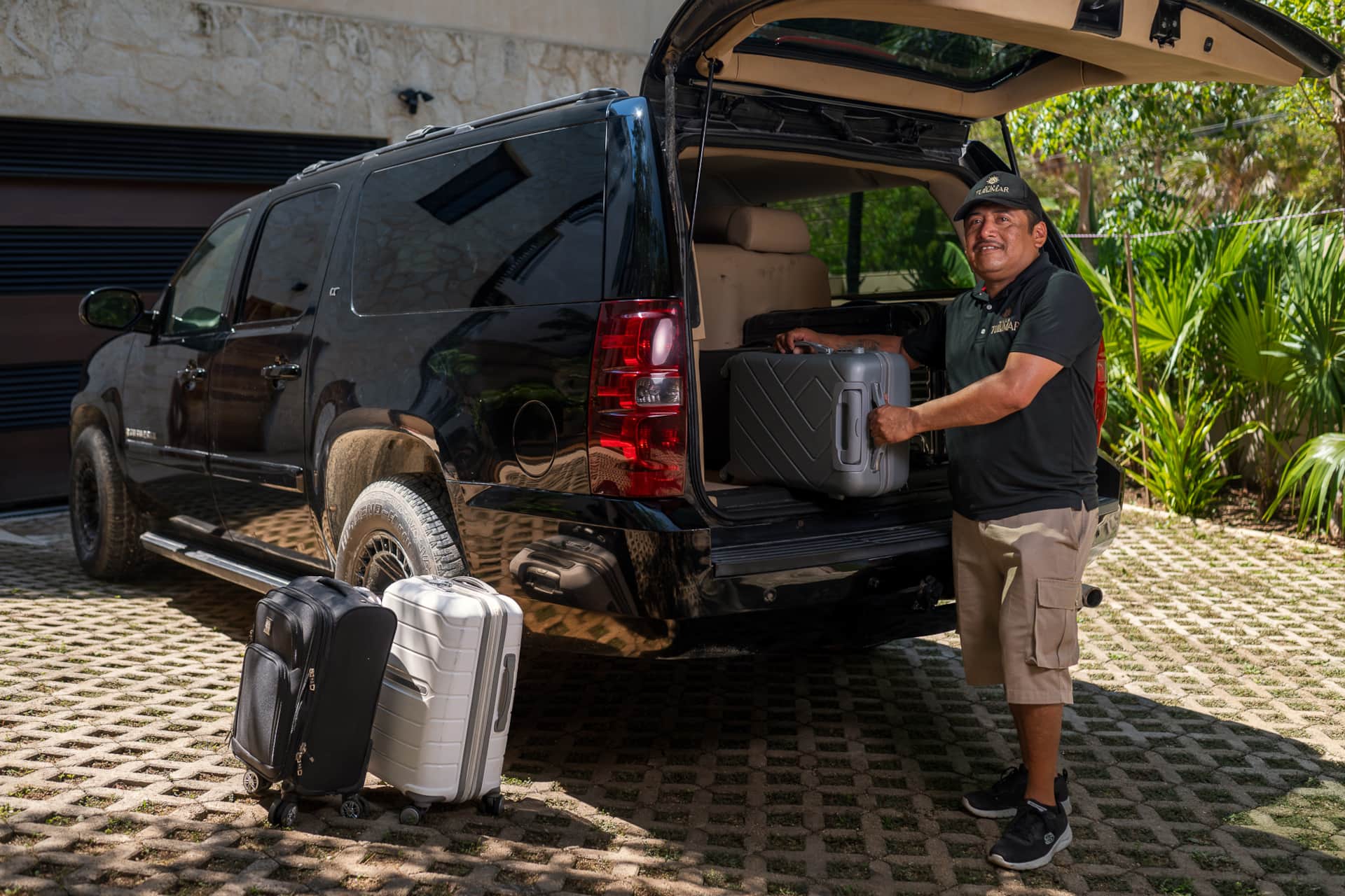 Chauffeur unloading luggage from Suburban at Villa TuluMar