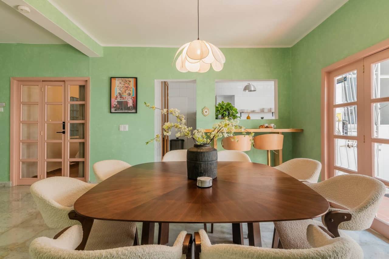 Dining room with round wooden table and gallery wall at Casa Atlixco