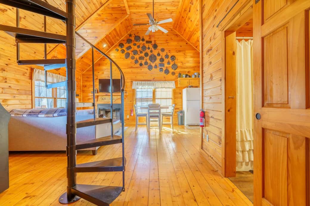 View from the entryway of the bedrooms. Full bathroom to the right and a large entry to the living area. A beautiful spiral staircase leads to the workspace and also an extra sleeping area equipped with a futon and bedding.