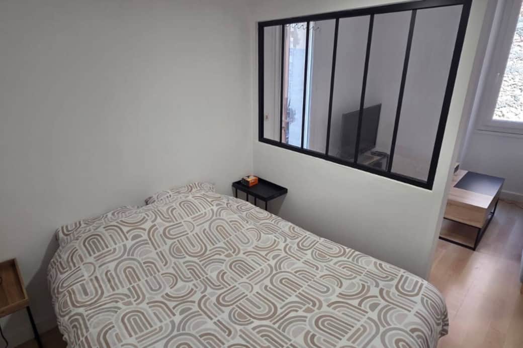 Côté chambre avec un lit double et deux tables de nuit.