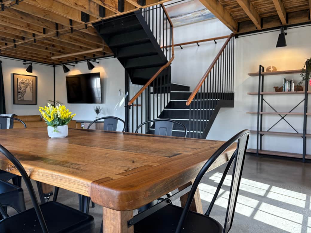 The open-plan living & dining area includes a large dining table, bookcase, sofas and smart TV.