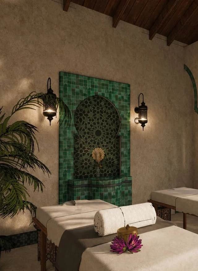 Green tiled fountain and massage table in the private spa