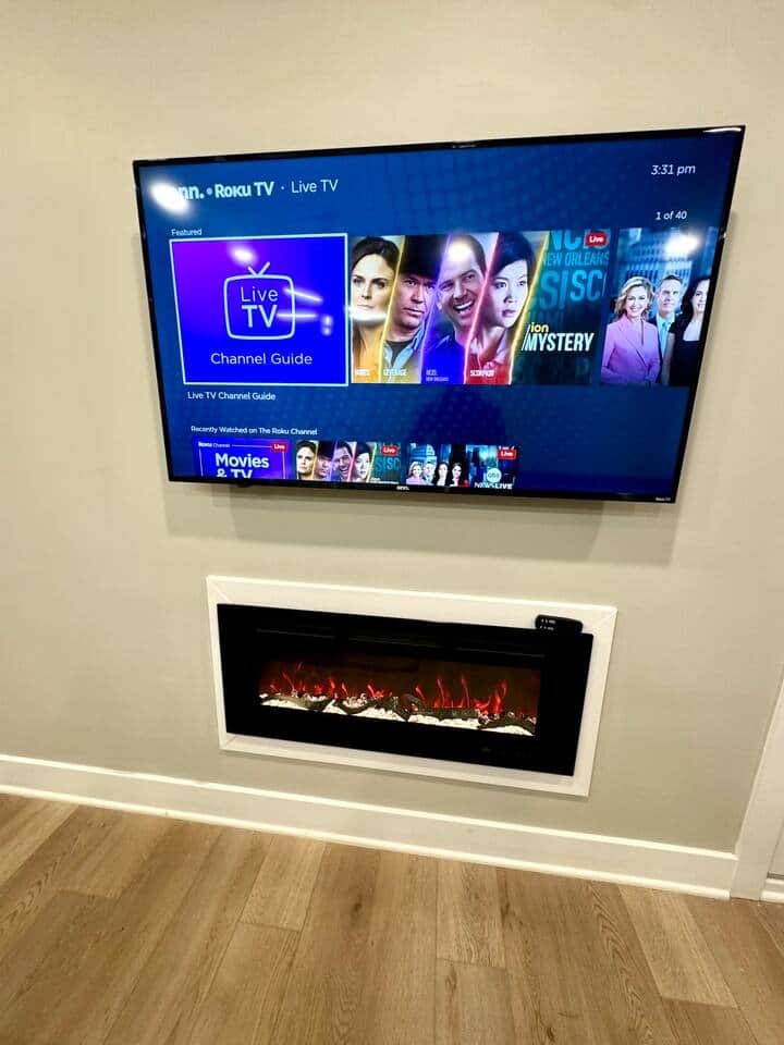 flatscreen TV with Roku channels And electric fireplace.