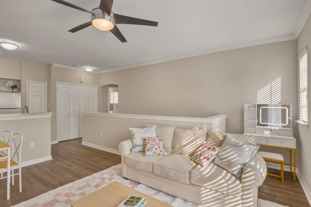 A chic seating nook featuring a plush sofa with blush pillows, perfectly positioned in front of a stylish vanity. A chic seating nook featuring a plush sofa with blush pillows, perfectly positioned in front of a stylish vanity.