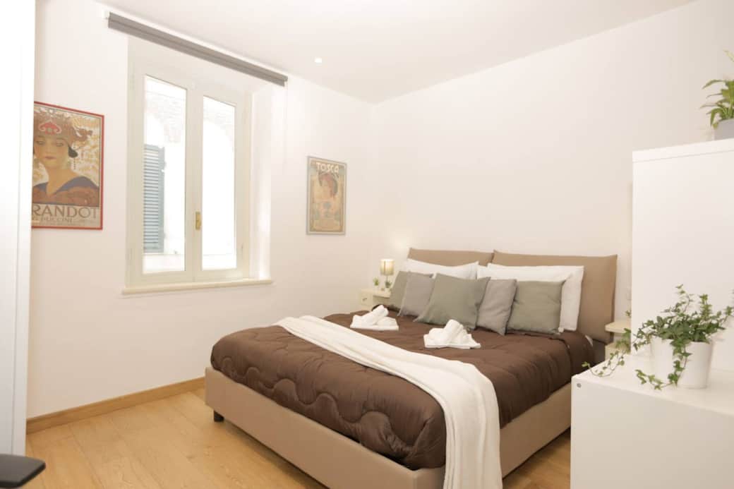 Camera da letto matrimoniale accogliente e luminosa, separata dal salotto da un elegante separè che garantisce privacy e comfort. Letto ampio con materasso comodo, ideale per un riposo rigenerante in un ambiente intimo e ben curato.
