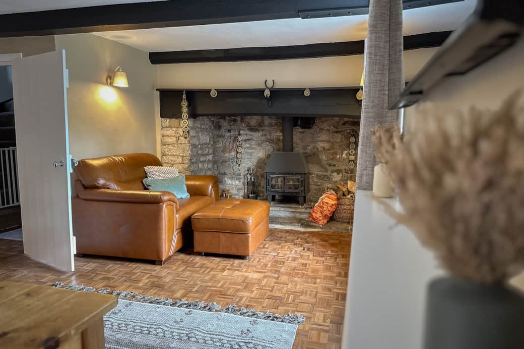 Cuddle chair by the log burner. looking out the window into the garden and stables over the road