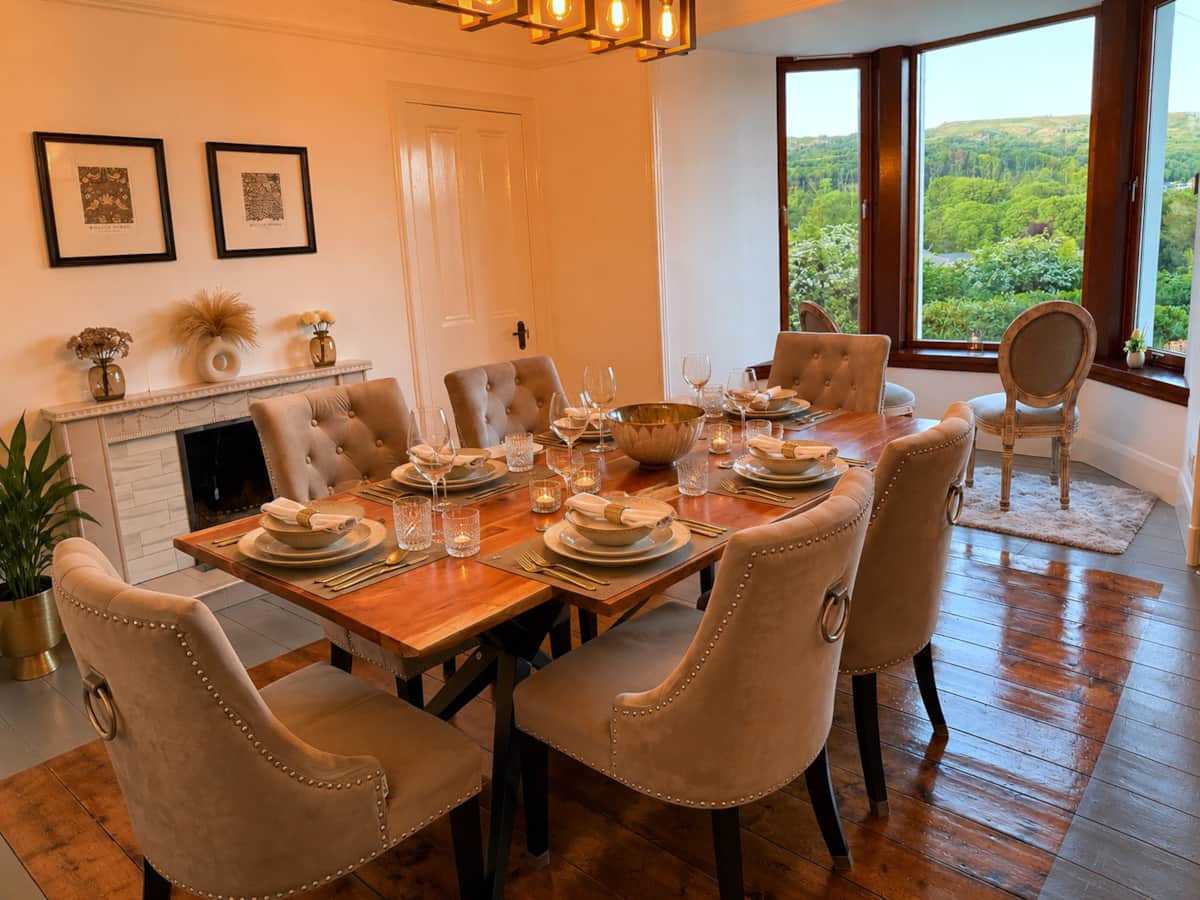 Dining room with button-back chairs, a timber dining table and a garden bay window.