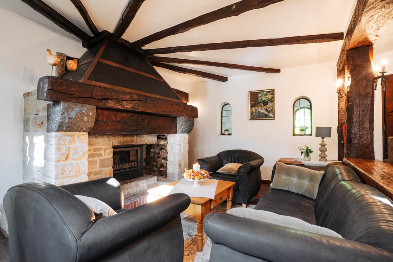 Fireplace lounge with exposed beams and armchairs
