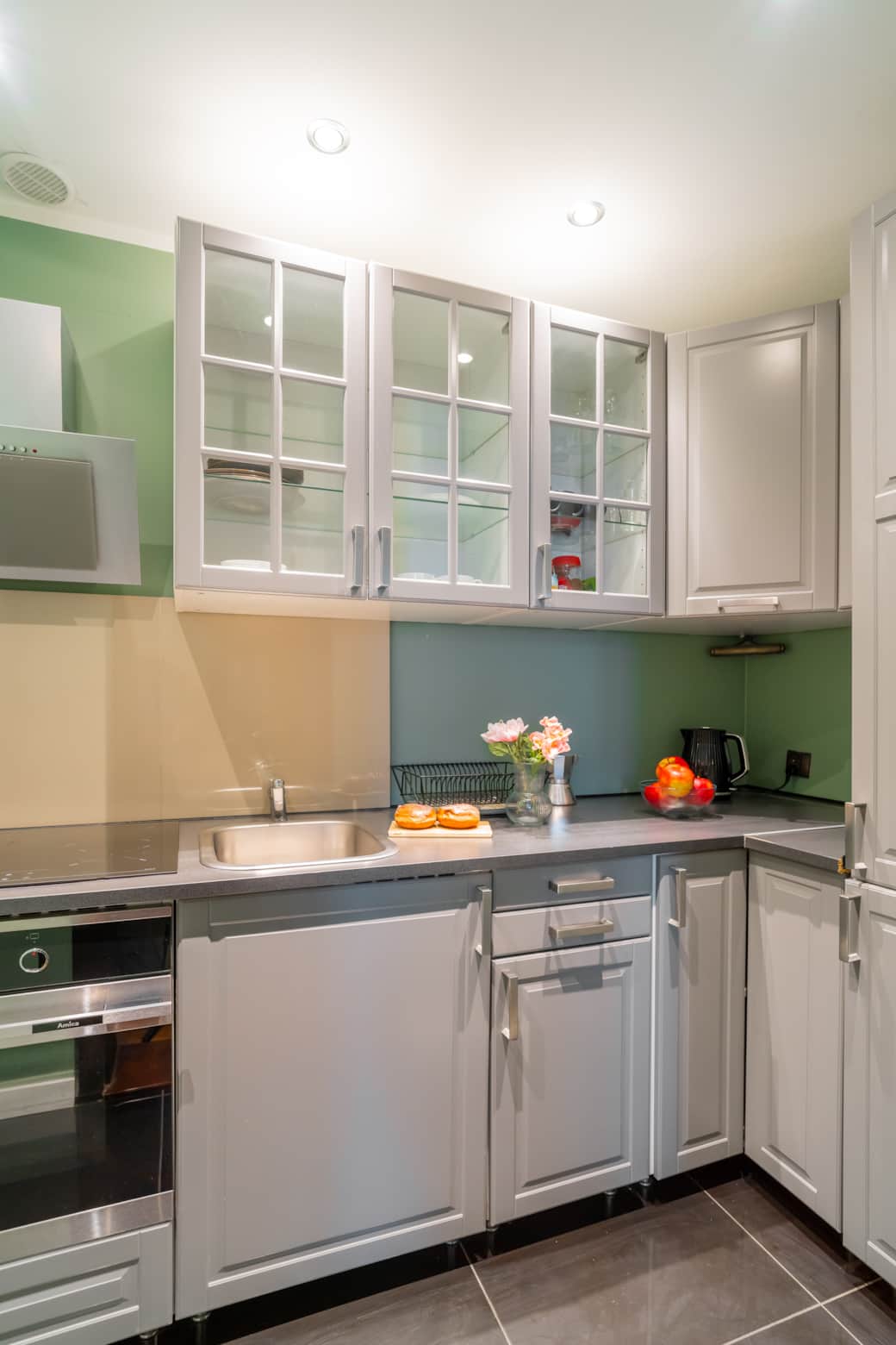 Stylowy, funkcjonalny aneks kuchenny z jasnymi szafkami i wygodną przestrzenią roboczą.