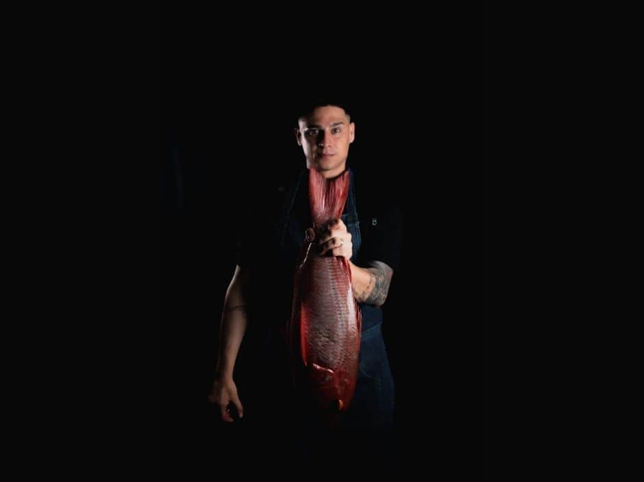 Private chef at Villa Sueño holding a large fish.