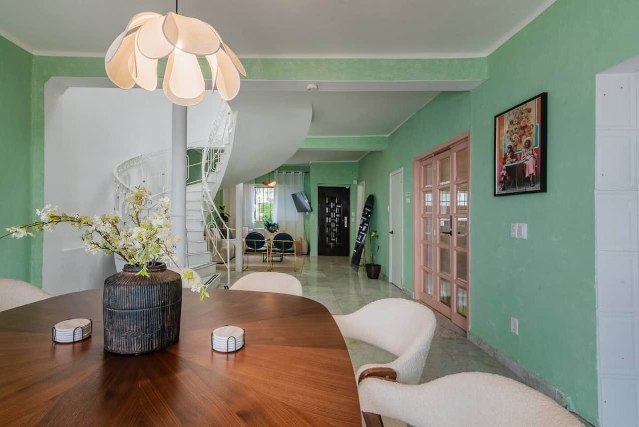 Open living room with green walls and garden view at Casa Atlixco
