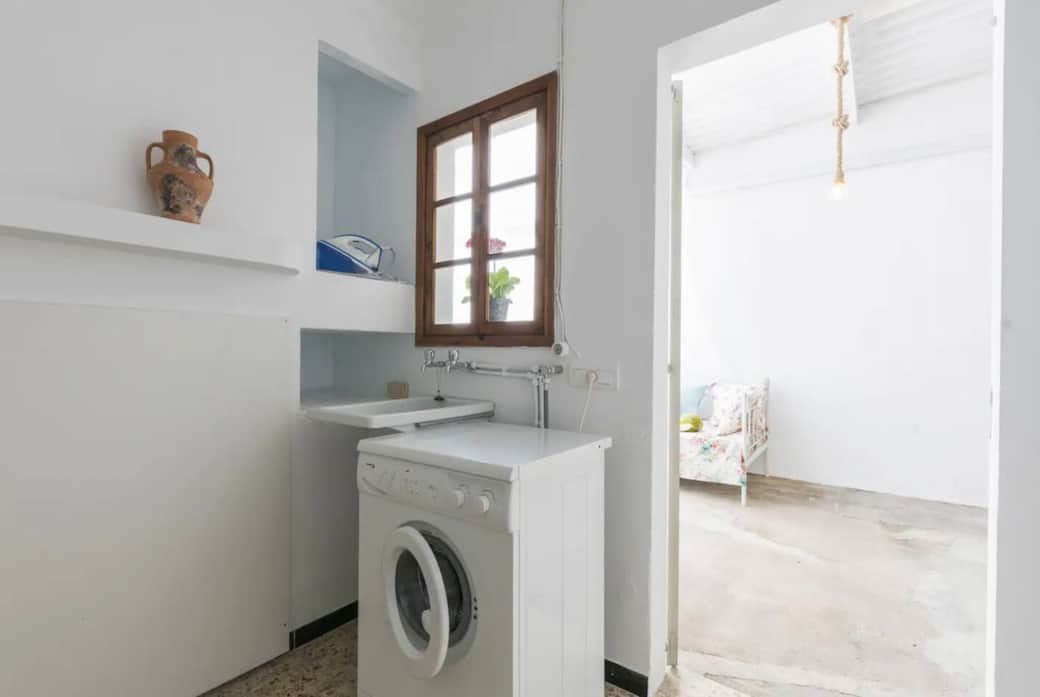 La lavanderie avec lave-linge, étendoirs et fer à repasser