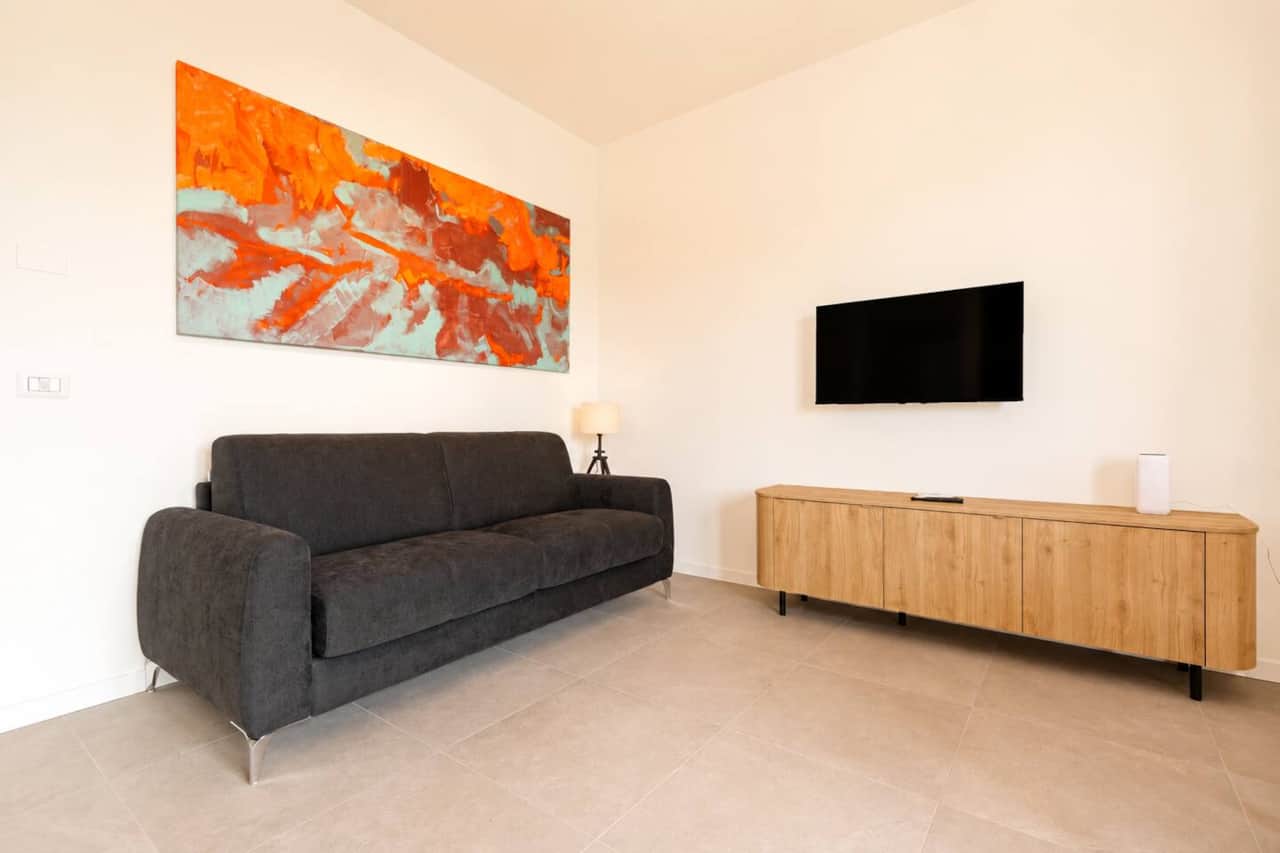 Soggiorno accogliente con divano letto, smart tv, wifi, tavolo da pranzo, cucina open space, accesso al balcone 