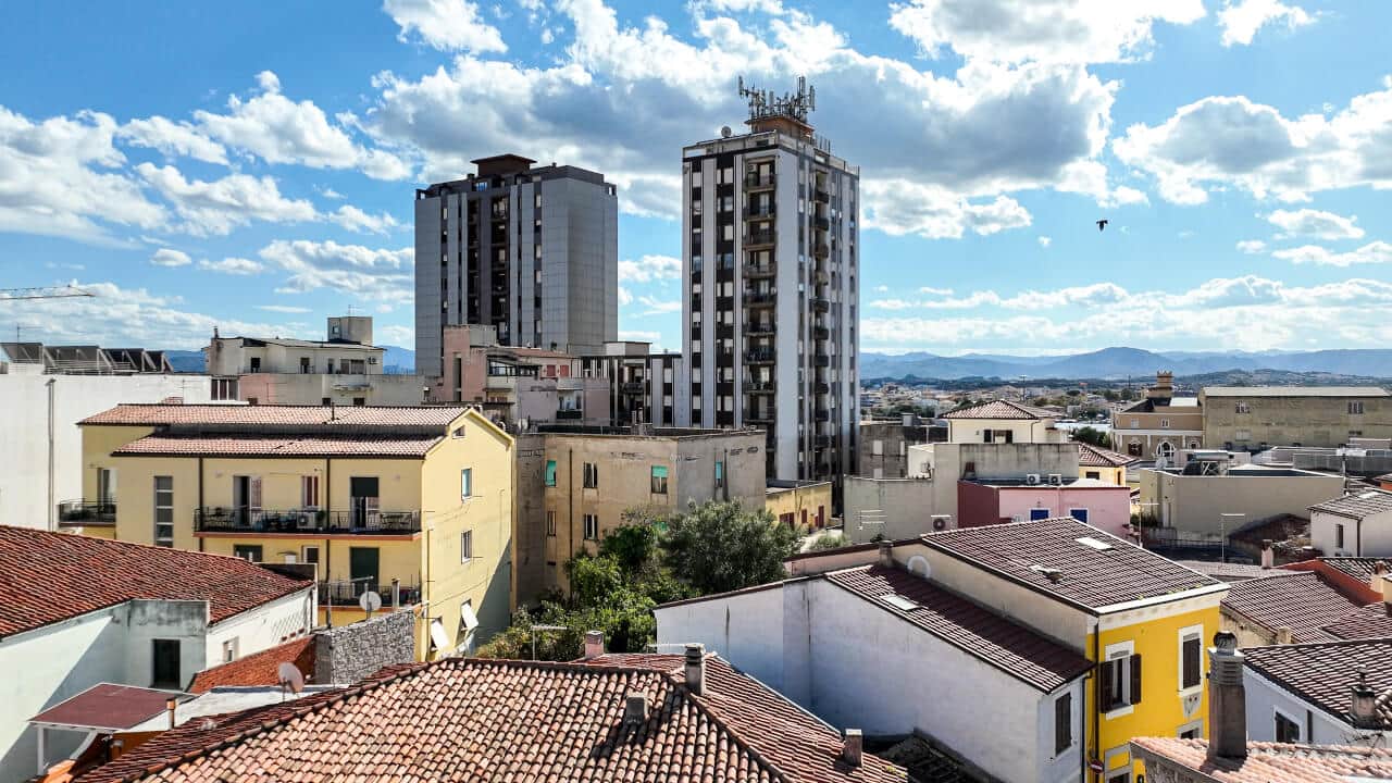 Corso Umberto I, Olbia — the main pedestrian street lined with colourful buildings, restaurants and mountain views in North East Sardinia. Photo by RENTAL12.