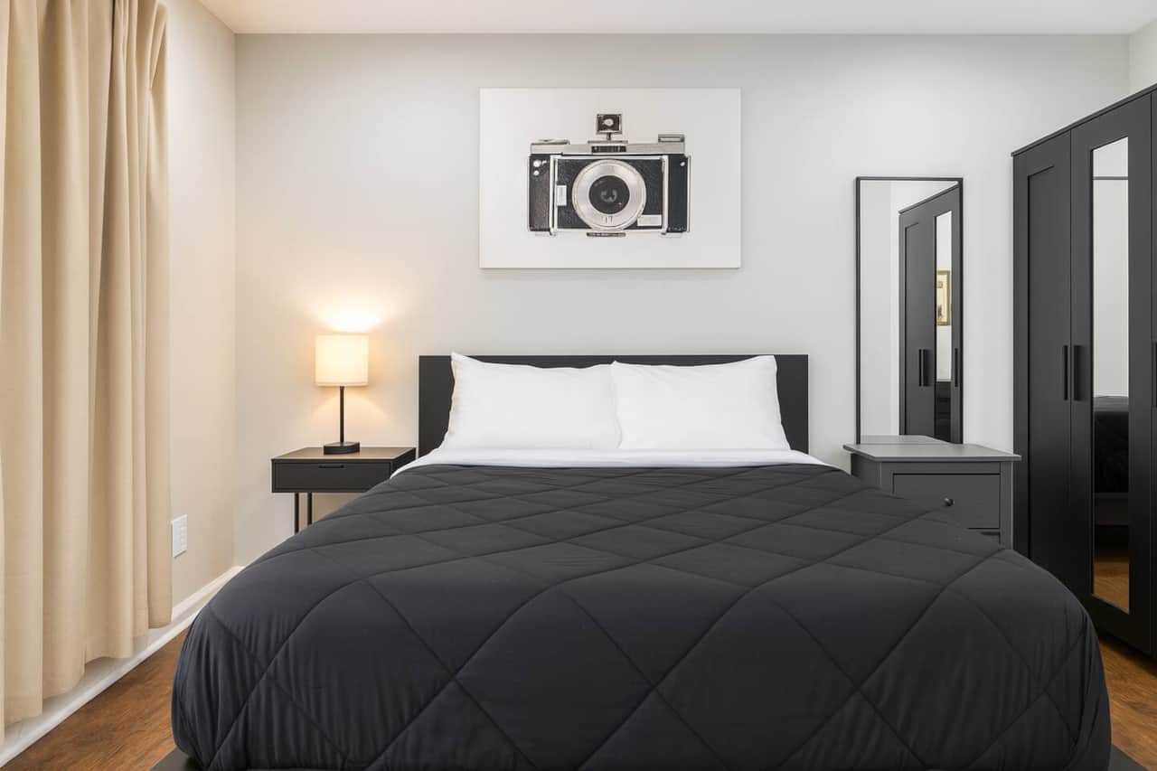 
“Cozy bedroom featuring a comfortable queen-size bed, a mounted flatscreen TV, ample closet space, and a dedicated work desk—perfect for relaxing or getting things done during your stay.”