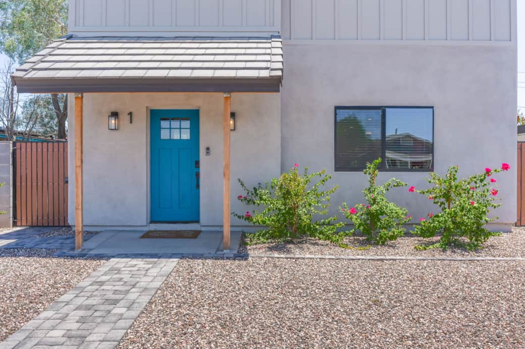 Bright, welcoming entryway with vibrant desert landscaping.