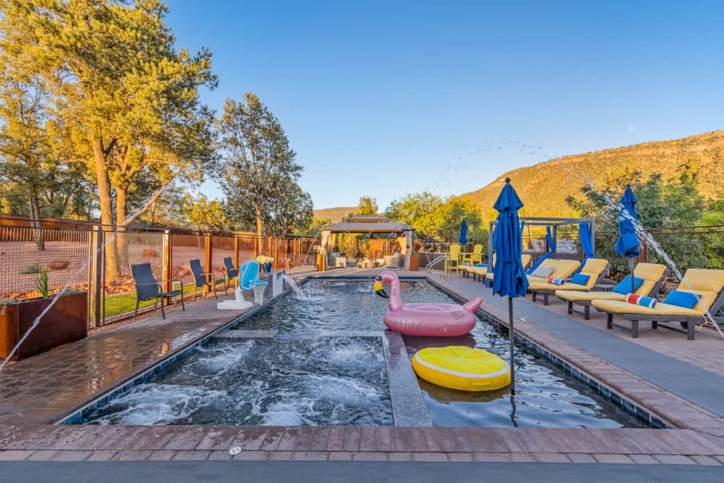 Pool toys, pool towels, lounge chairs, day bed, cold plunge, bbq, and cozy firepit seating area