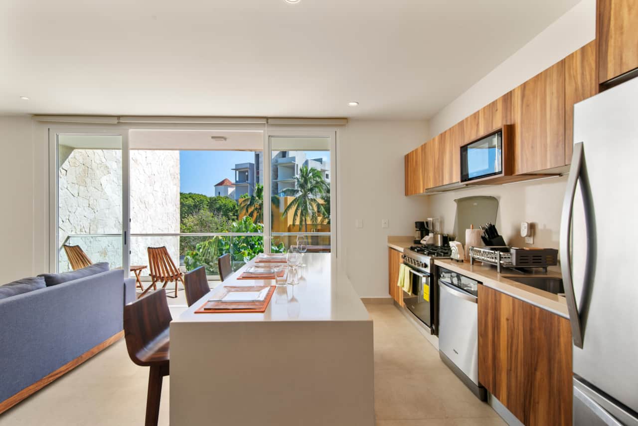 Fully equipped kitchen & dining area with balcony access.