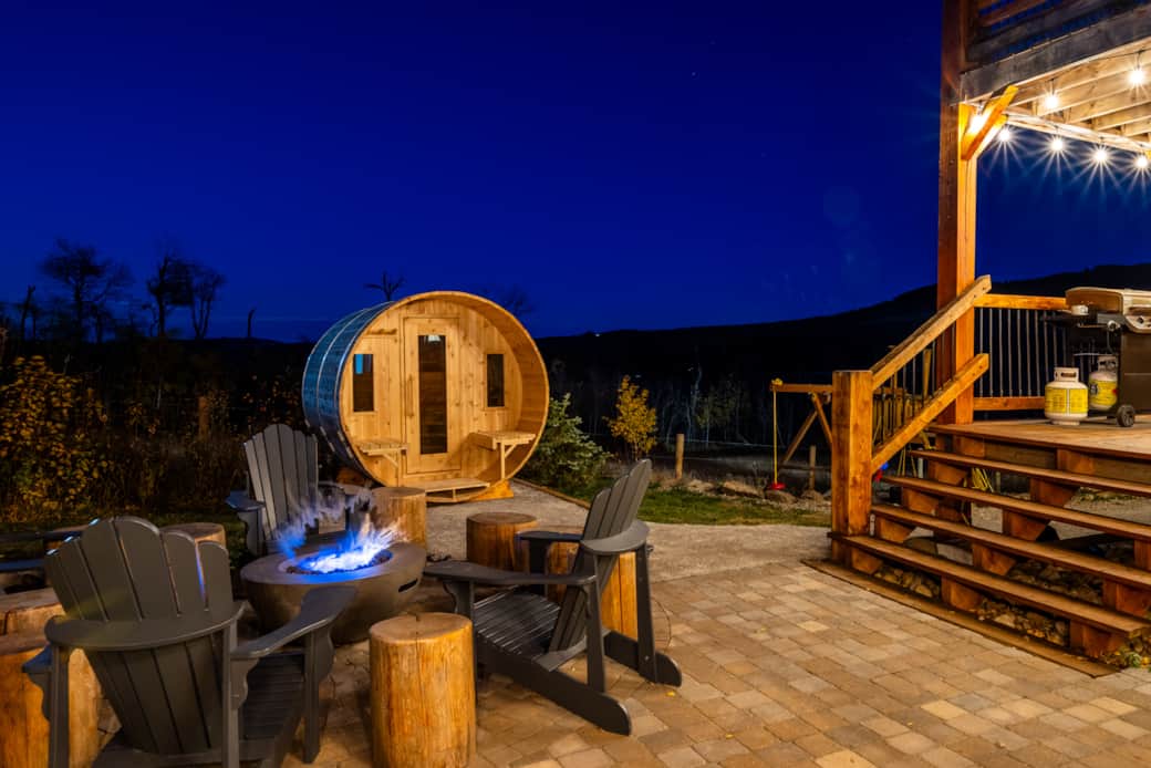 Chat into the night with custom natural gas fire table and cedar barrel sauna right off the covered Chat into the night with custom natural gas fire table and cedar barrel sauna right off the covered