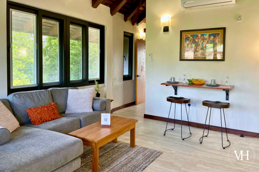 Spacious living area with bright windows, Smart TV, comfy seating, and board games. 