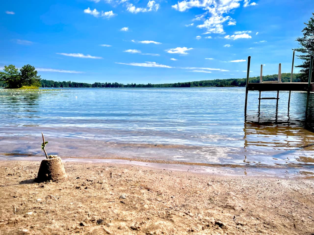 A sandy lakeshore for sunbathing, playing, and swimming.