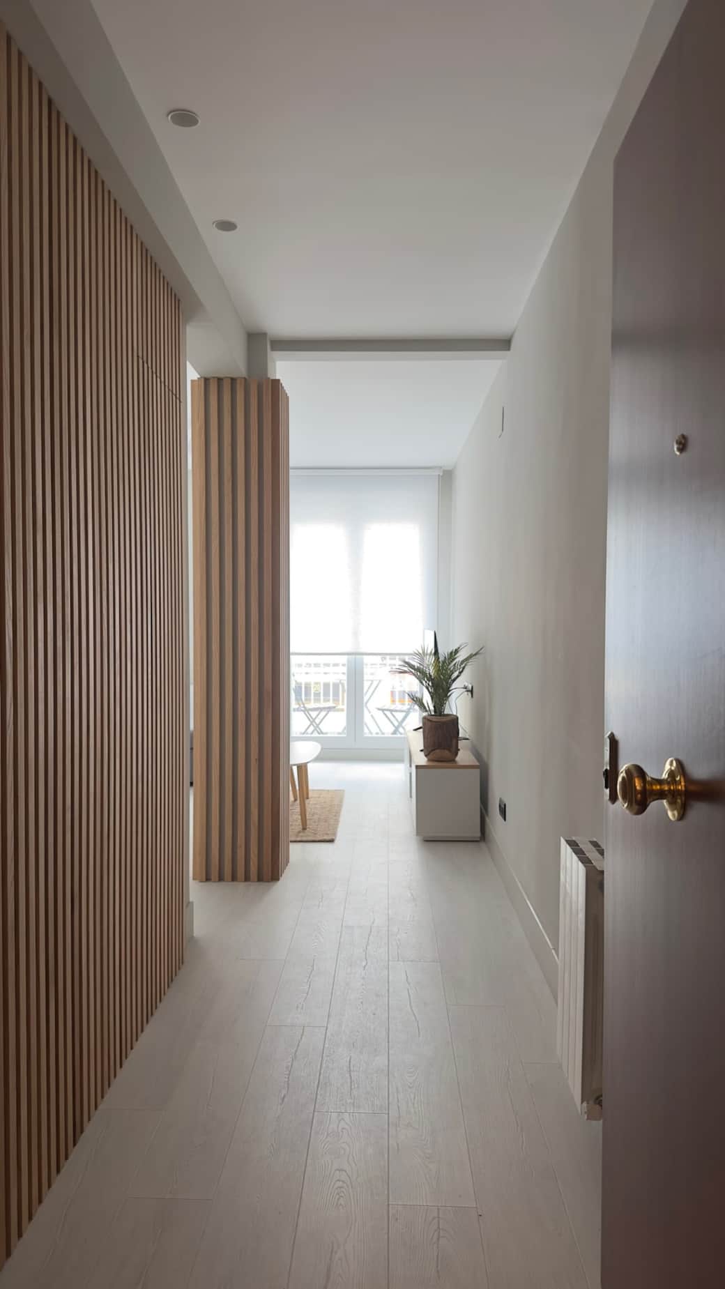 Entrada al apartamento. Los baños quedan escondidos a la izquierda, ya que las puertas son la misma pared de laminas de madera. Entrada al apartamento. Los baños quedan escondidos a la izquierda, ya que las puertas son la misma pared de laminas de madera.