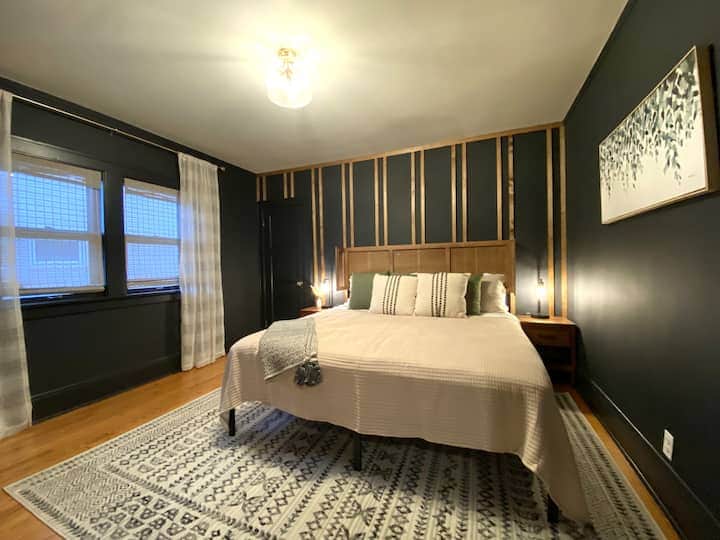 Stylish bedroom with bold accent walls, warm wood details, and a plush bed for ultimate comfort.