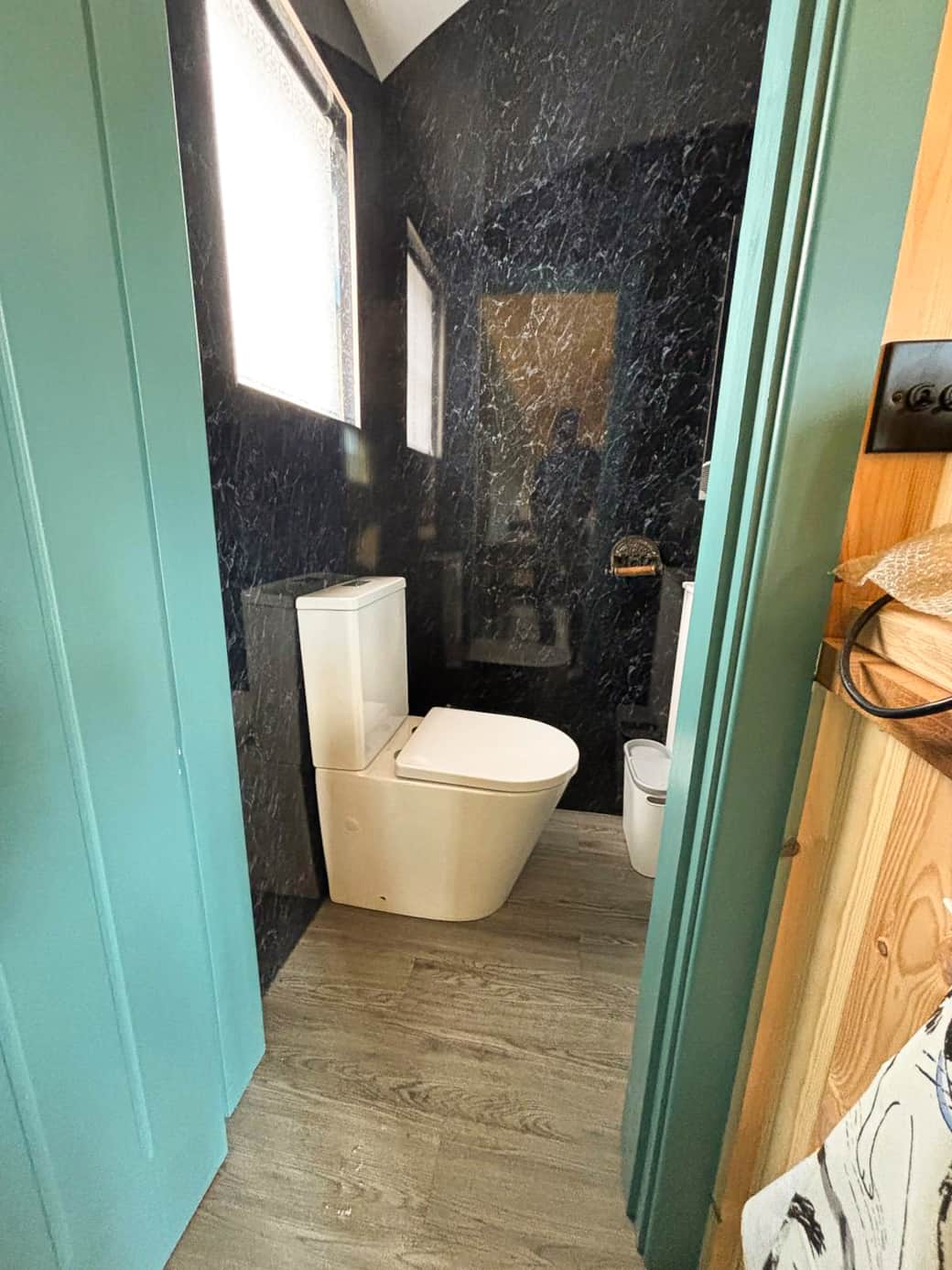 Modern bathroom with dark feature walls and contemporary fittings.