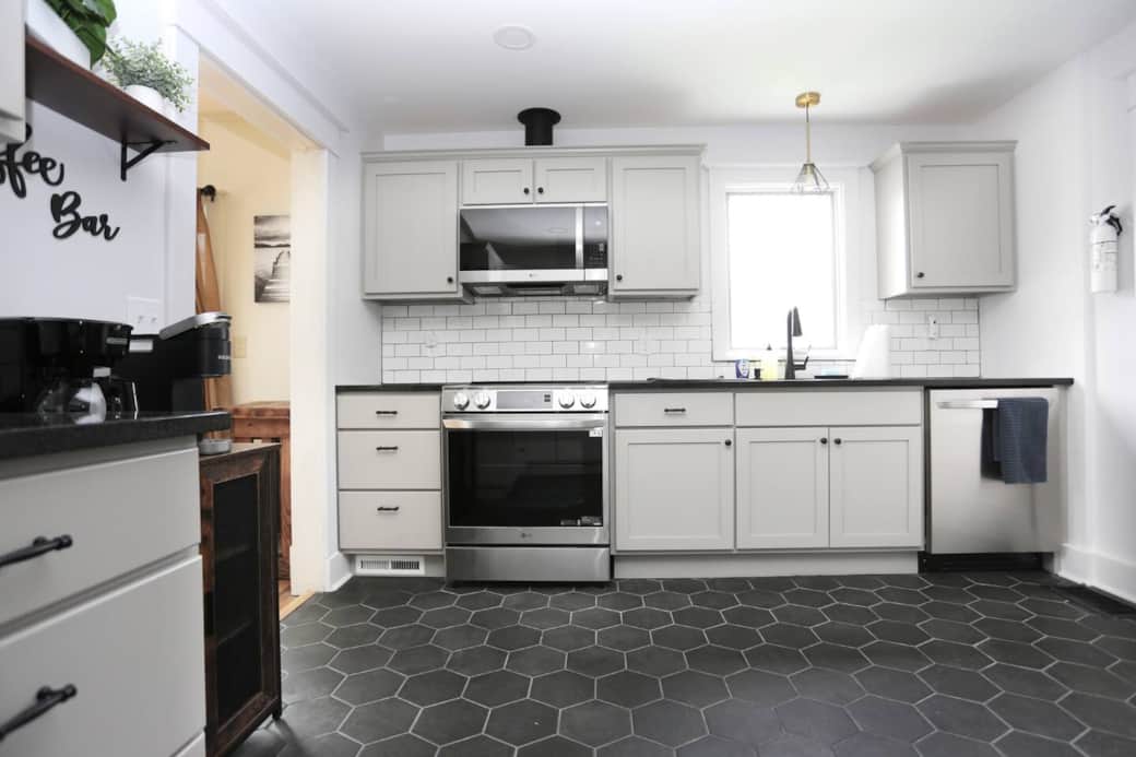Modern kitchen with induction stove, dishwasher, coffee bar & full cookware.
