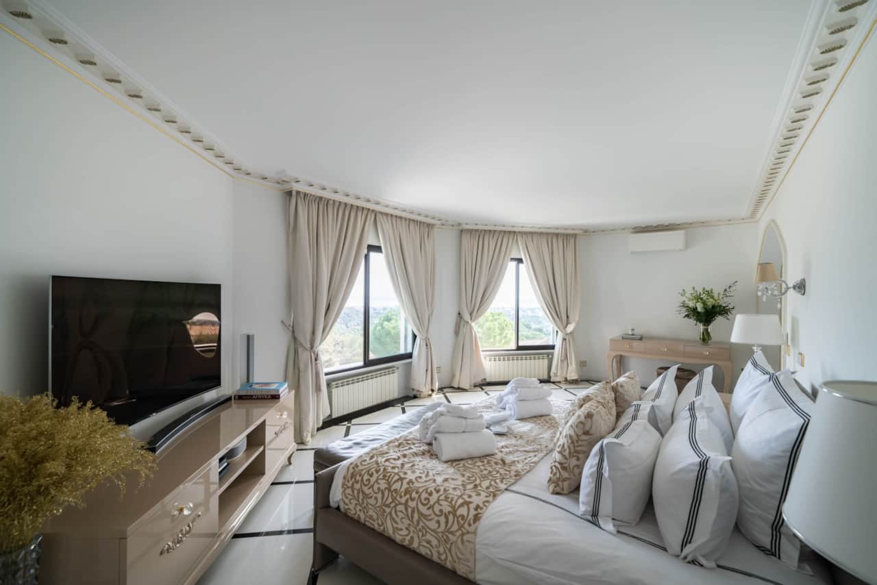 Master bedroom with TV and panoramic bay windows