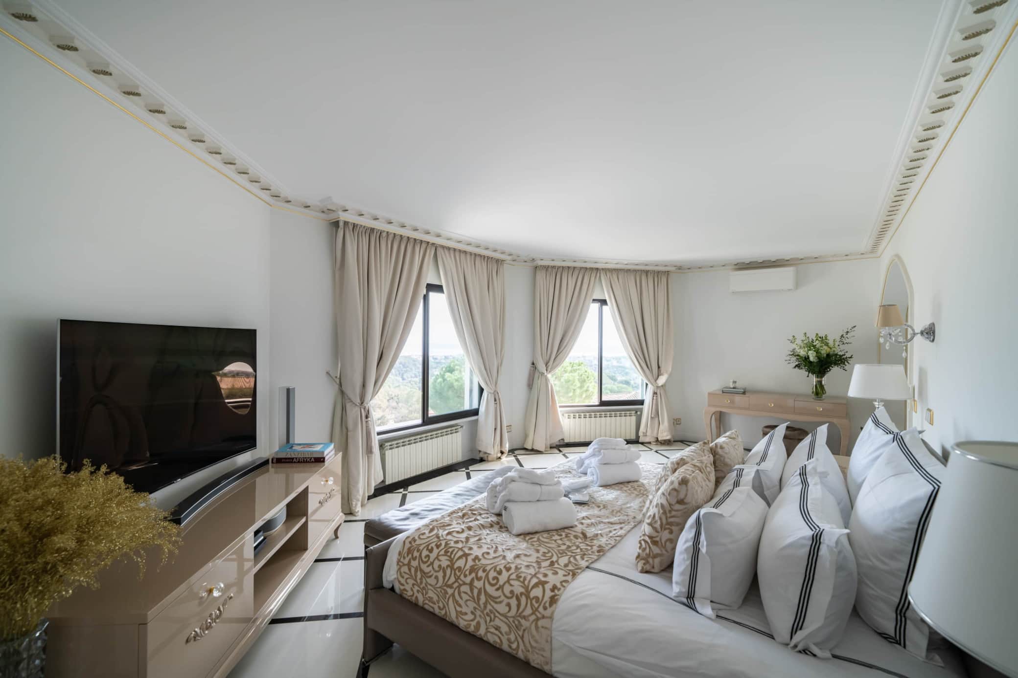 Master bedroom with TV and panoramic bay windows