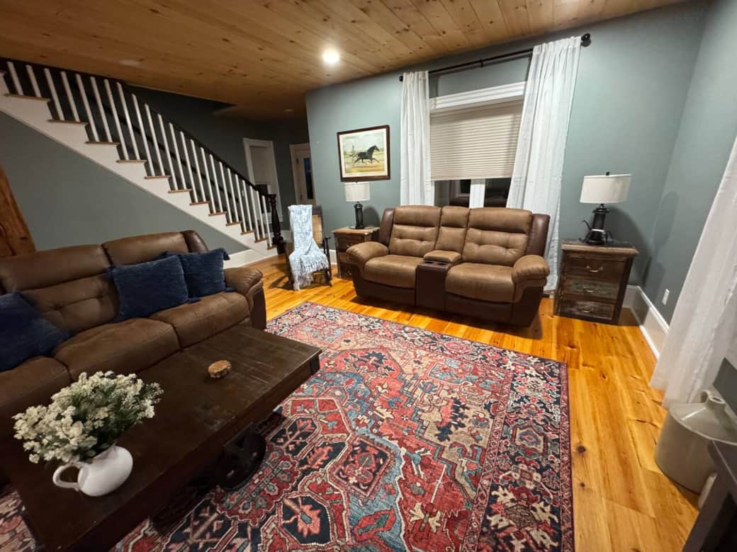 A beautifully designed living room blending rustic wood tones, comfy seating, and curated décor for a peaceful retreat.