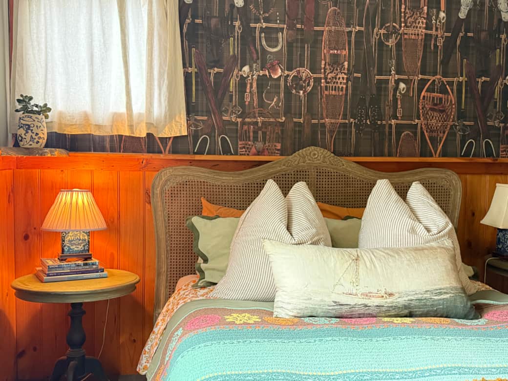 first bedroom with queen size bed and antique bench from Switzerland