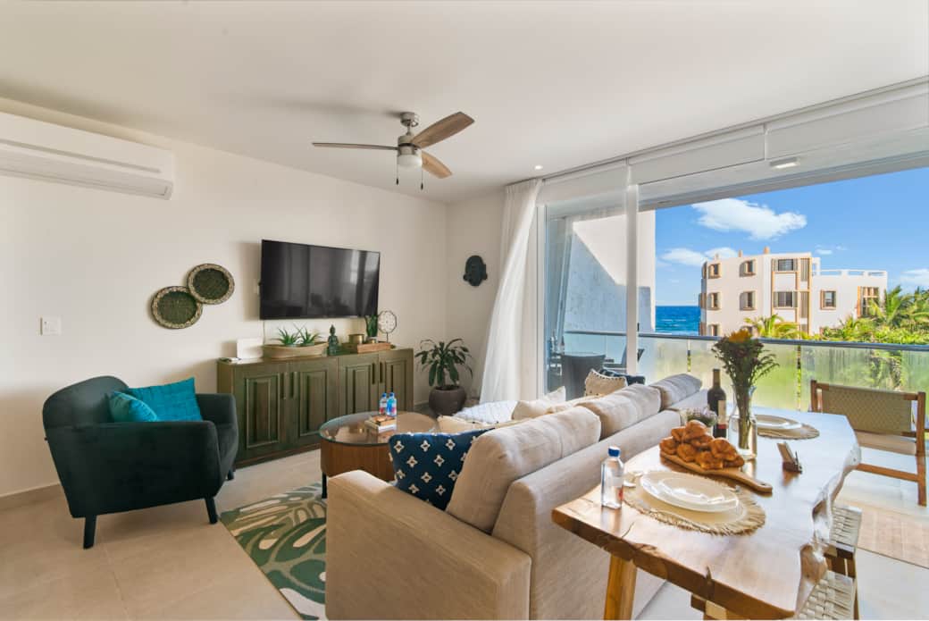 Cozy living room with sofa bed opens to balcony with ocean views.