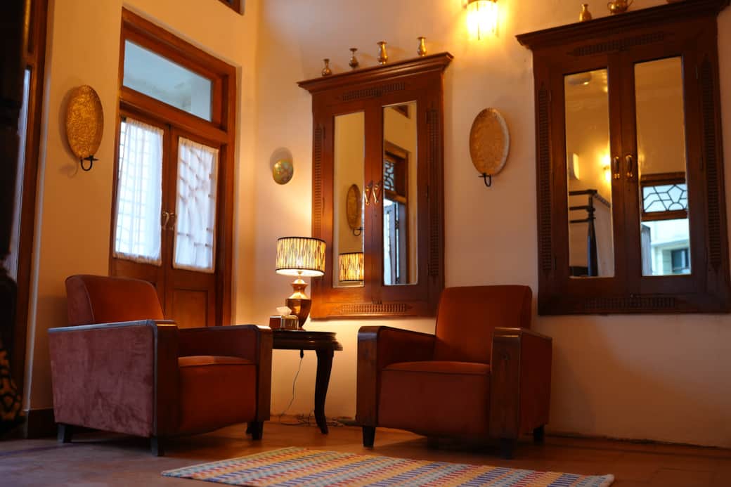 Nazara’s cozy corner with twin velvet chairs glowing in soft lamplight warmth