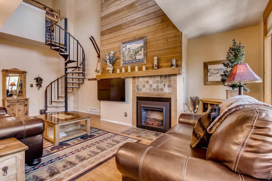 Living room with spiral staircase leading to master bedroom and loft area Living room with spiral staircase leading to master bedroom and loft area