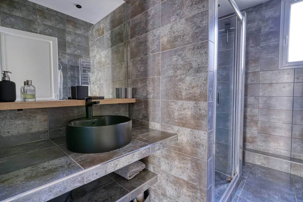 Salle de bain spacieuse avec lavabo moderne et douche à l'italienne. Profitez d'un espace bien agencé et décoré avec goût.