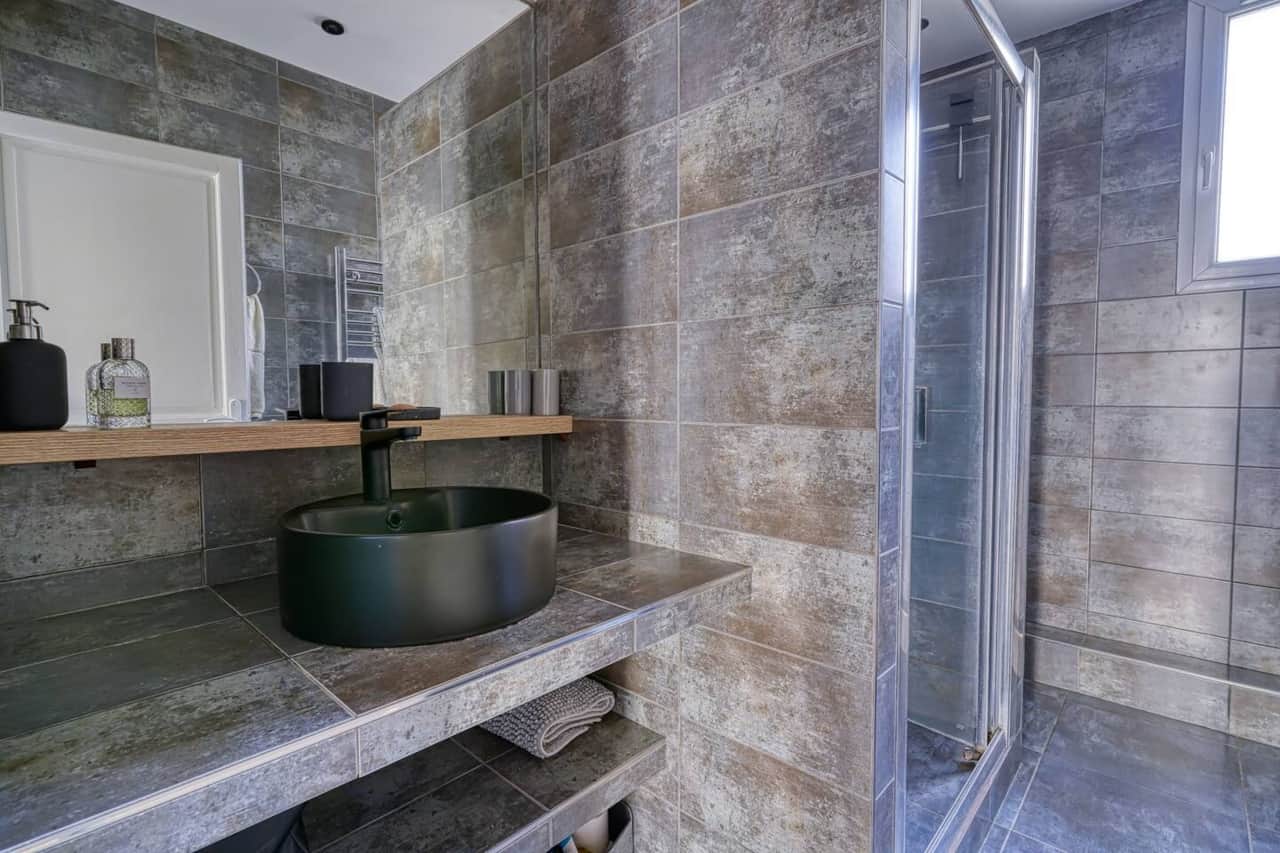 Salle de bain spacieuse avec lavabo moderne et douche à l'italienne. Profitez d'un espace bien agencé et décoré avec goût.